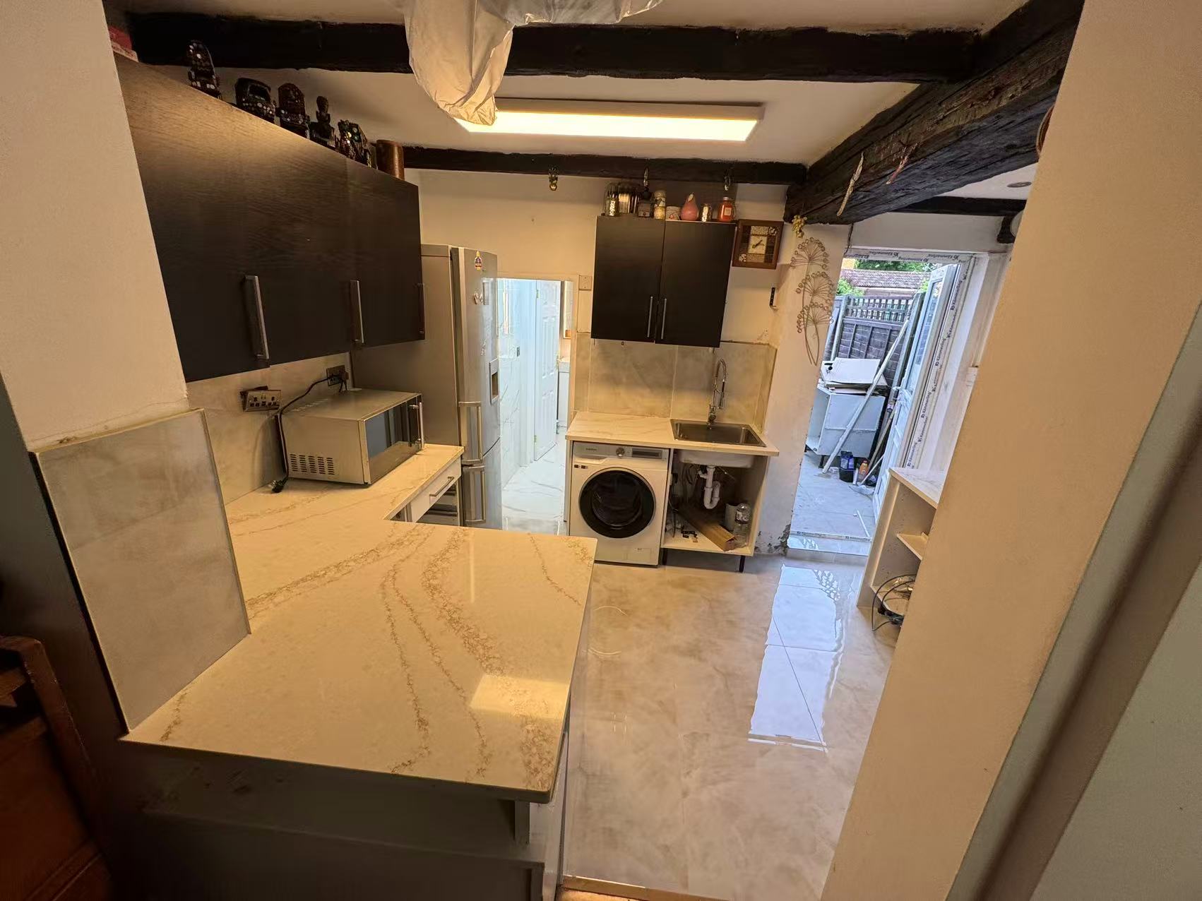 Marble-effect kitchen floor and splashback tiling, period cottage — image 1
