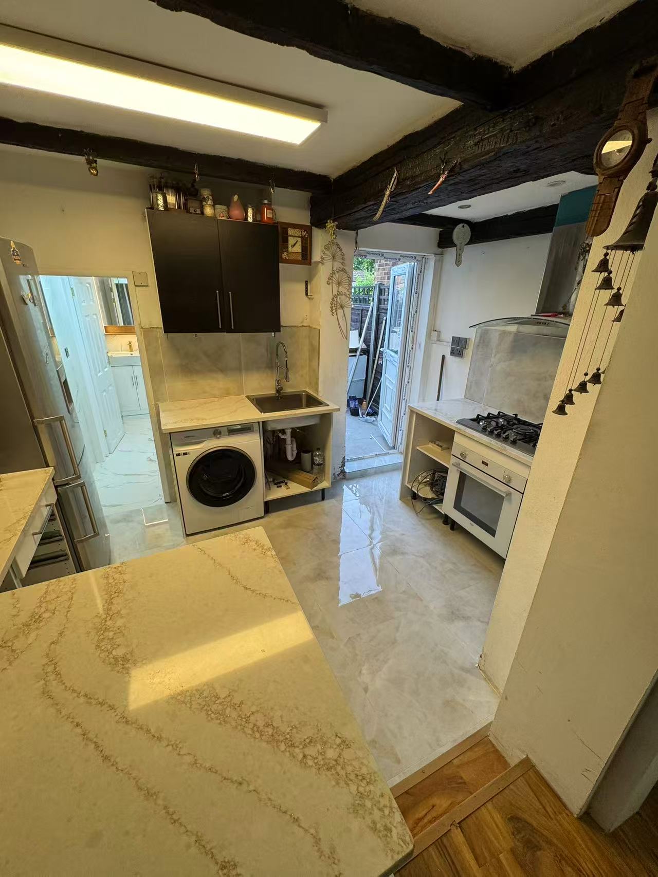 Marble-effect kitchen floor and splashback tiling, period cottage — image 2